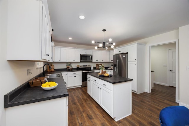 kitchen with sink, a center island, hanging light fixtures, appliances with stainless steel finishes, and white cabinets