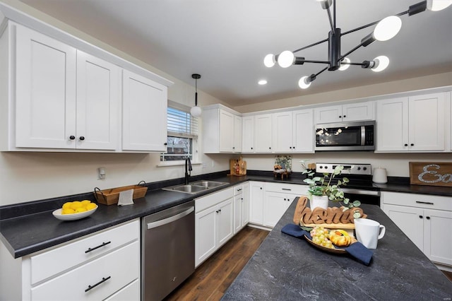 kitchen with sink, decorative light fixtures, white cabinets, and appliances with stainless steel finishes