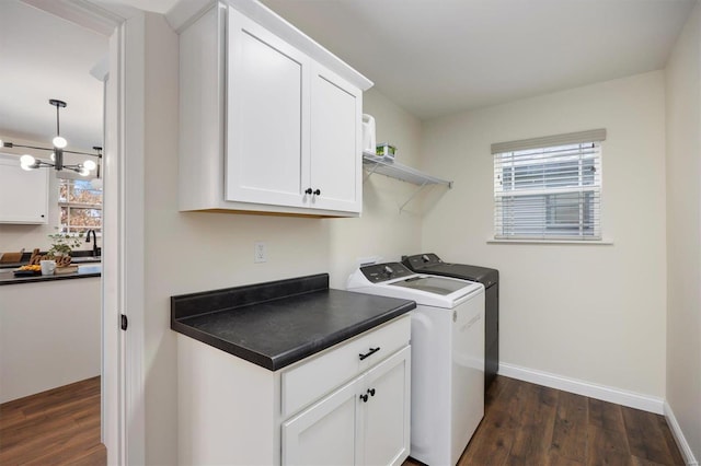 laundry room with cabinets, sink, washer and dryer, and dark wood-type flooring