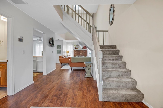 staircase featuring hardwood / wood-style floors and ceiling fan