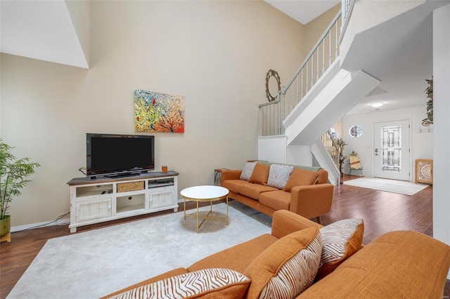 living room featuring dark wood-type flooring and a high ceiling