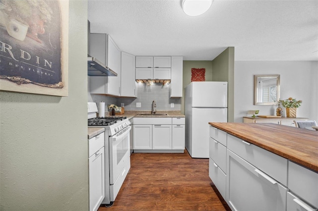 kitchen featuring sink, white appliances, dark wood-type flooring, white cabinets, and decorative backsplash