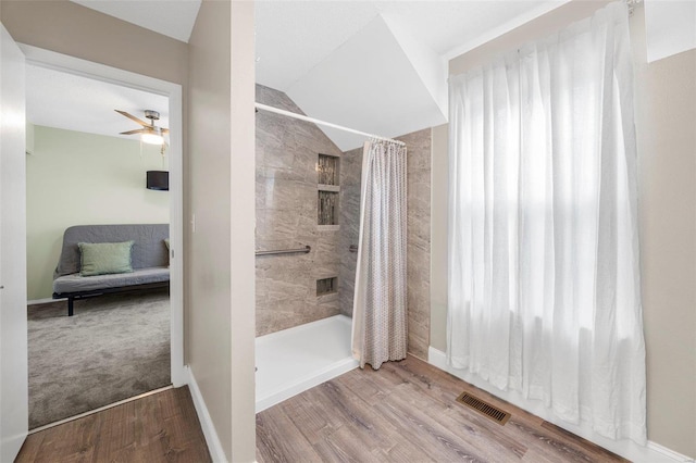 bathroom featuring lofted ceiling, hardwood / wood-style flooring, ceiling fan, and a shower with shower curtain