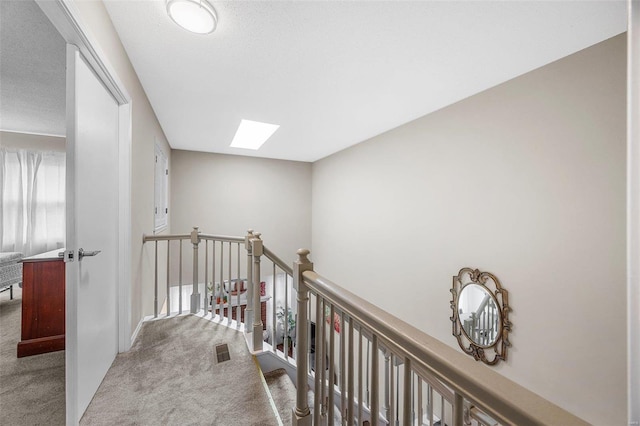 hall with carpet floors and a skylight