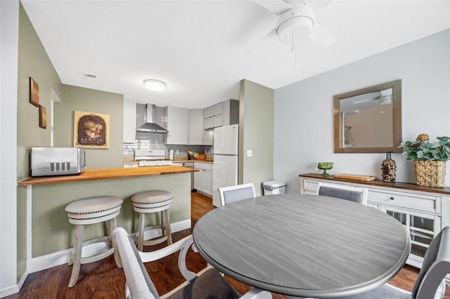 dining area featuring dark wood-type flooring and ceiling fan