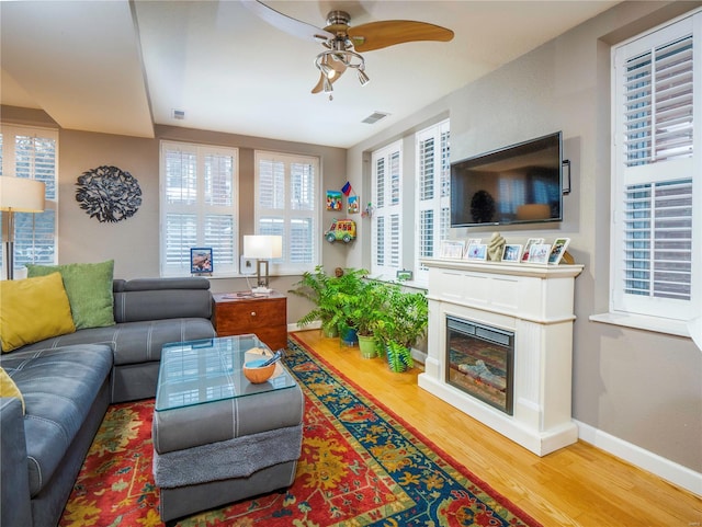 living room with wood-type flooring and ceiling fan