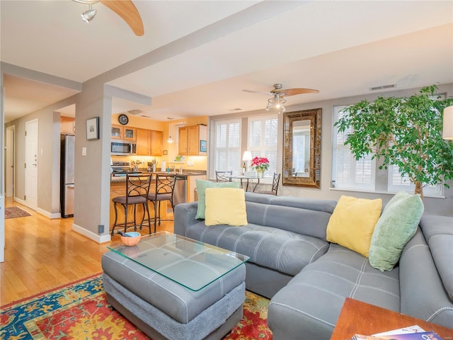 living room with ceiling fan and light wood-type flooring