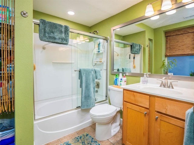 full bathroom featuring vanity, combined bath / shower with glass door, tile patterned floors, and toilet