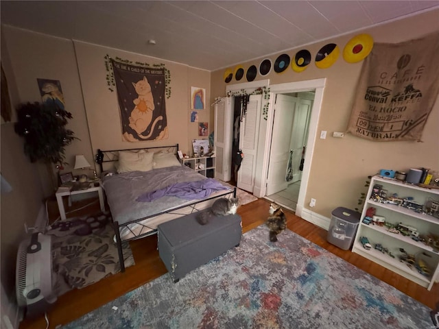 bedroom with baseboards and wood finished floors