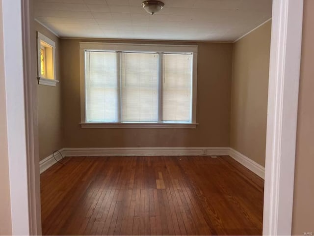 unfurnished room featuring crown molding, hardwood / wood-style floors, and baseboards