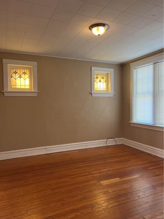 unfurnished room with hardwood / wood-style flooring and baseboards