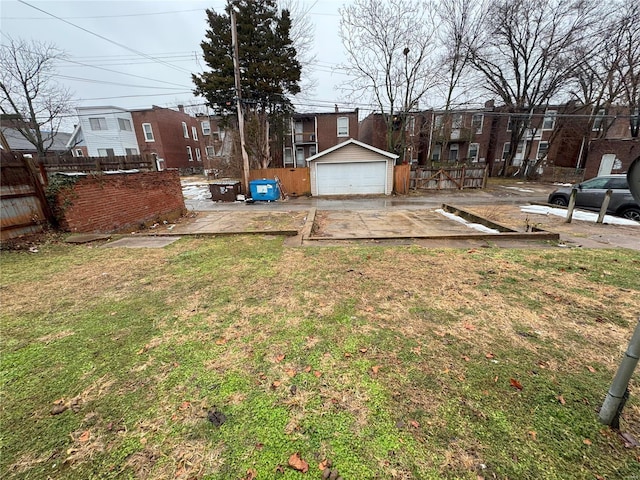 view of yard featuring a garage, an outdoor structure, and fence