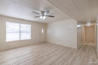 empty room with light hardwood / wood-style flooring and ceiling fan