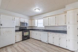 kitchen featuring white appliances, light hardwood / wood-style flooring, and white cabinets