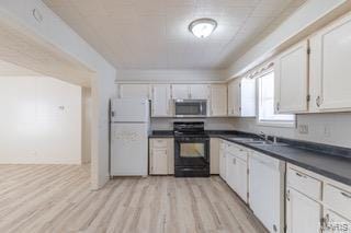 kitchen with black electric range oven, sink, light hardwood / wood-style floors, white cabinets, and white fridge