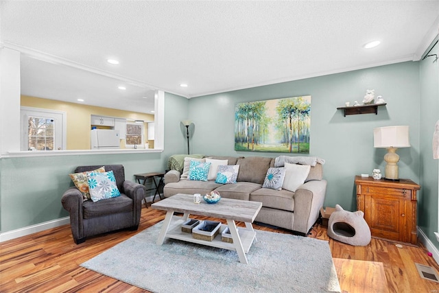 living room with a textured ceiling and light wood-type flooring