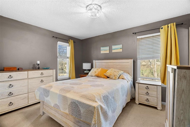 bedroom featuring light carpet and a textured ceiling