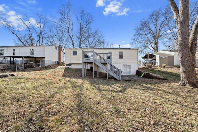 back of house featuring a wooden deck and a lawn