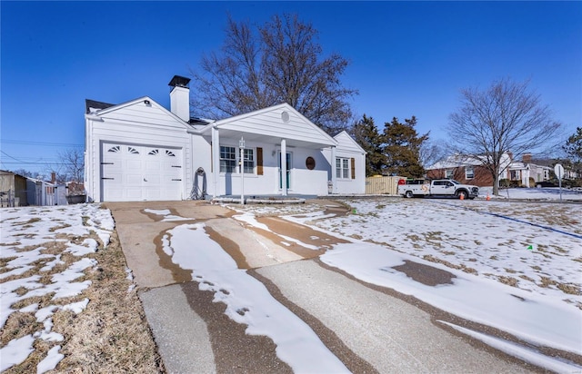 view of front of house featuring a garage, a chimney, a porch, and concrete driveway