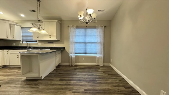 kitchen featuring sink, white cabinets, a chandelier, dark hardwood / wood-style flooring, and hanging light fixtures