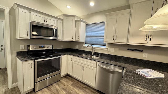 kitchen with hardwood / wood-style flooring, stainless steel appliances, sink, and white cabinets