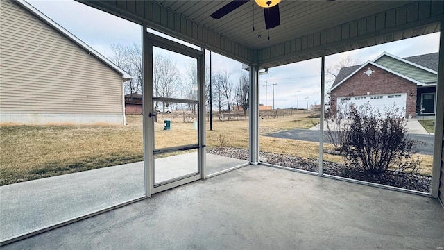 unfurnished sunroom featuring ceiling fan