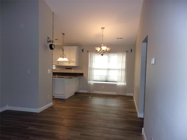 kitchen with white cabinetry, dark hardwood / wood-style floors, a chandelier, and decorative light fixtures