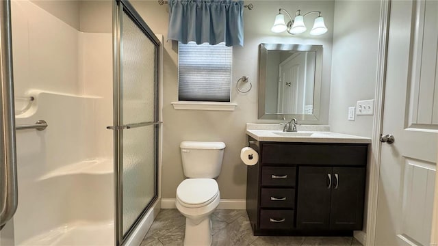 bathroom featuring vanity, toilet, and a shower with shower door