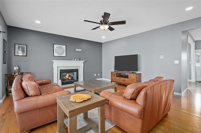 living room featuring ceiling fan and light hardwood / wood-style flooring