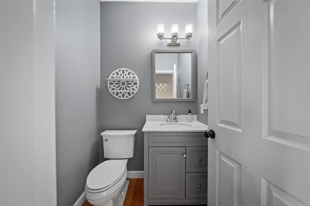 bathroom with vanity, hardwood / wood-style floors, and toilet