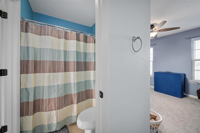 bathroom with walk in shower, ceiling fan, and toilet