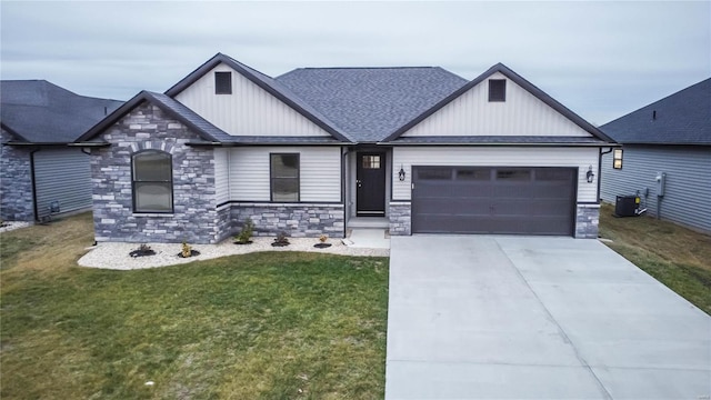 view of front of home with central AC, a garage, and a front lawn