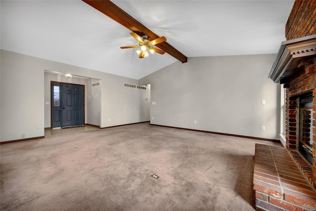 unfurnished living room featuring lofted ceiling with beams, a brick fireplace, carpet floors, and ceiling fan