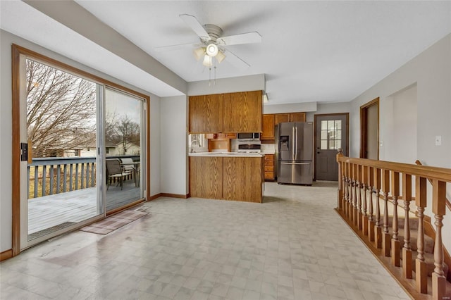 kitchen featuring sink, kitchen peninsula, ceiling fan, and appliances with stainless steel finishes