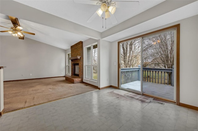 unfurnished living room with light colored carpet, ceiling fan, a fireplace, and vaulted ceiling