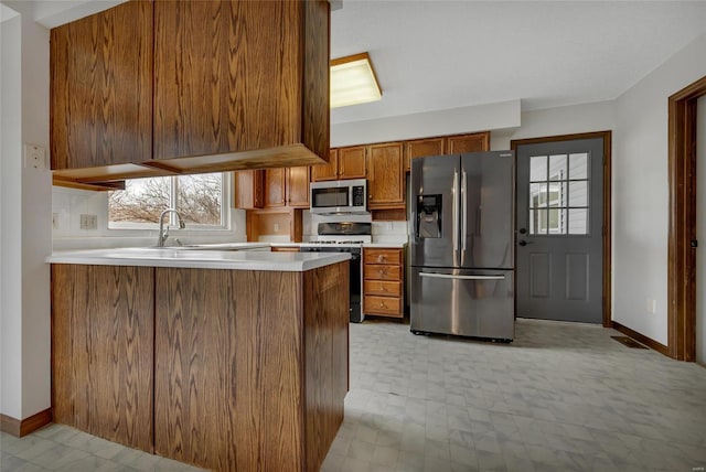 kitchen with stainless steel appliances, sink, and kitchen peninsula