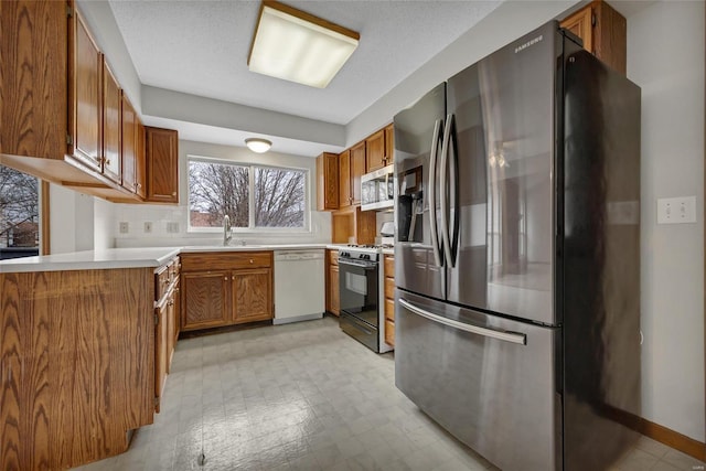 kitchen featuring stainless steel appliances, sink, a textured ceiling, and decorative backsplash