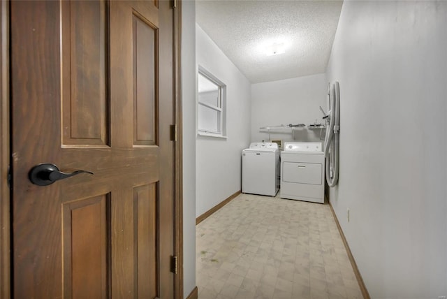 clothes washing area featuring washer and clothes dryer and a textured ceiling