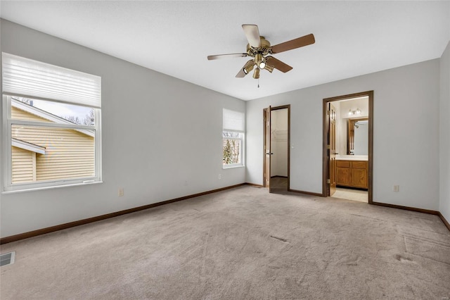 unfurnished bedroom with light carpet, connected bathroom, and ceiling fan