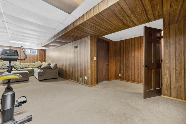 exercise room featuring light colored carpet and wood walls