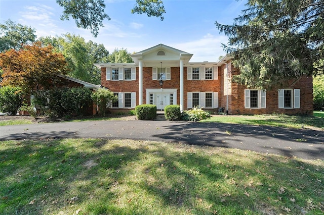 neoclassical home featuring a front yard and french doors