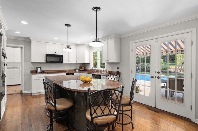 kitchen featuring white cabinetry, black appliances, a kitchen island, decorative light fixtures, and french doors