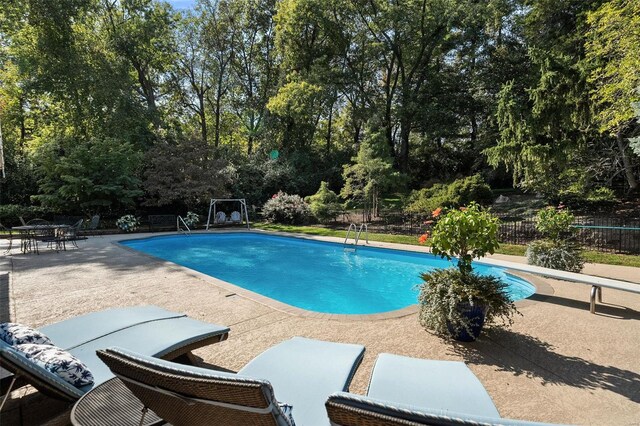 view of pool featuring a patio and a diving board