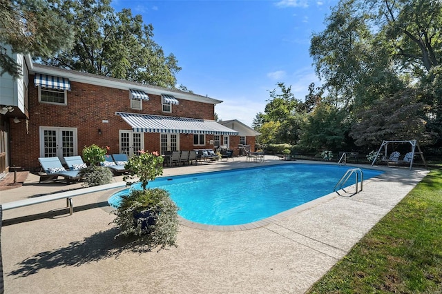 view of pool featuring french doors, a diving board, and a patio