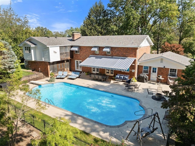 view of pool with an outdoor living space, a diving board, and a patio