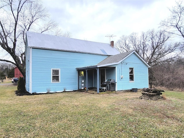 back of house featuring a lawn