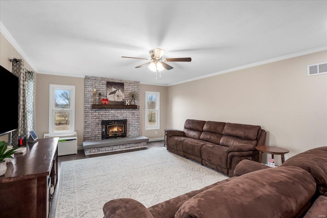 living room featuring a fireplace, ornamental molding, hardwood / wood-style flooring, and ceiling fan