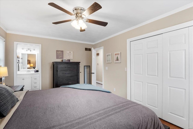 bedroom with a closet, ensuite bathroom, crown molding, and ceiling fan