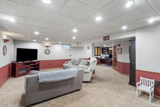 living room featuring carpet flooring and a drop ceiling