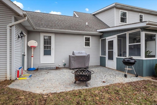 view of patio with an outdoor fire pit, area for grilling, and a sunroom